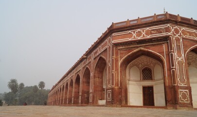 Obraz premium A long corridor,arches and pillars in red sandstone and white marble of Humayun's Tomb,a monument in Delhi, India