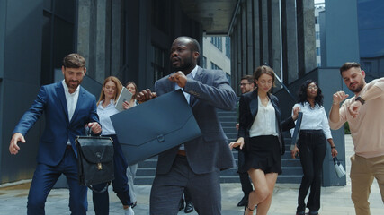 Euphoric interracial group of office co-workers celebrating success at work, dancing fun together rejoicing victory. Business people. Corporate staff. Party. Celebration.