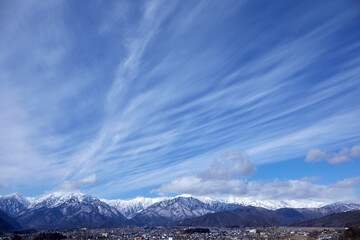 青空にすじ雲（巻雲）がたなびく冬の北アルプス連山 長野県大町市