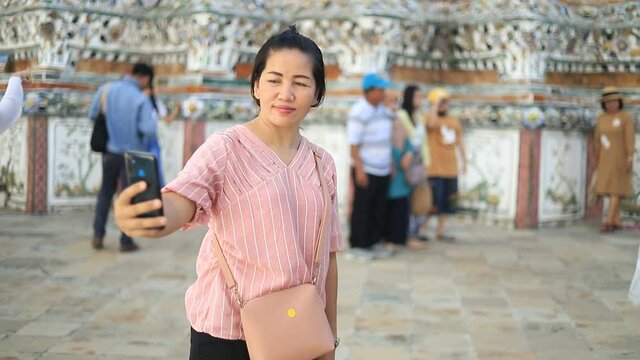 Asian girl take phone selfie photo travel in buddha temple in Bangkok Thailand