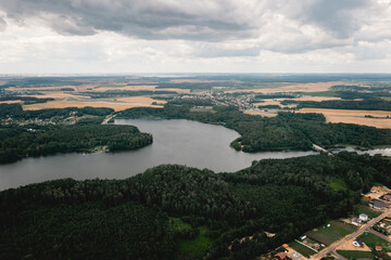 Obraz premium Aerial view over beautiful mountain lake and green forest. Spring or fall in the mountains. Green forest, mountain lake. Green pine and fir trees forest and a lake.beautiful landscape in belarus view 