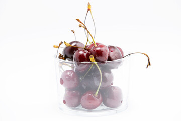 Fresh cherry fruits in glass bowl isolated on white background. Antioxidant, natural, vitamin, organic, vegetarian food berry. Selective focus.