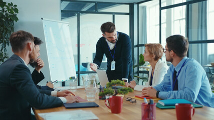 Chief bearded manager leading financial presentation for business partners, negotiating on future enterprise plans in coworking space boardroom. Business meeting.