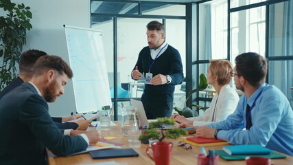 Chief bearded manager leading financial presentation for business partners, negotiating on future enterprise plans in coworking space boardroom. Business meeting.