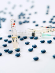 Close up view of the ampule with medicine, pills and syringe on white back 