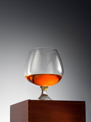 close up view of glass of whiskey on grey back. 