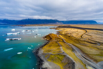 Fototapeta na wymiar Jökulsárlón is a glacial lagoon, bordering Vatnajökull National Park in southeastern Iceland. Its still, blue waters are dotted with icebergs from the surrounding Breiðamerkurjökull Glacier.