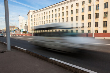 The movement of a blurred minibus along the overpass in the daytime.