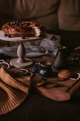 Still life of apple pie, berries, coffee and lemons on wooden tray