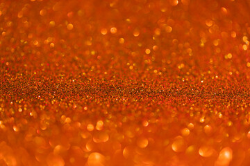 Shiny glitter celebration background. Orange saffron glitter bokeh background.