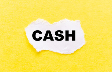 the inscription CASH on a white torn piece of paper on a yellow background