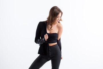 Beautiful woman in a black jacket posing in studio on a white background.