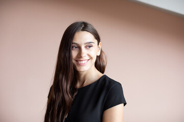 Portrait of a beautiful young business woman in a black business dress standing. Office worker.