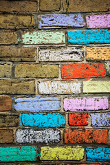 A brick wall with chalk colored bricks of many bright colors!.