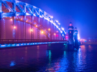 Obraz premium Saint Petersburg. Russia. Bridges of St. Petersburg. Bolsheokhtinsky bridge across the Neva river in the evening. Peter the Great bridge on the background of evening lights. Urban phantasmagoria.
