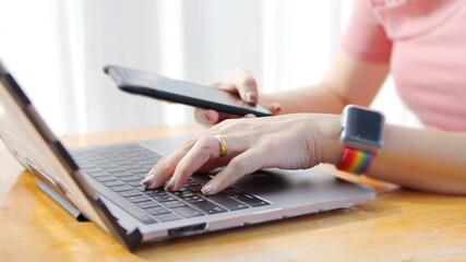 Fototapeta premium Person's hand operating a laptop touchpad and there is a graphic showing people, folder and globe icons, showing a network connection through the use of technology. Using technology concept.