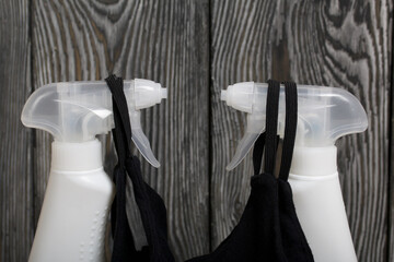 White plastic bottles with spray. Cleaning spray. They wear face masks to protect them from the...