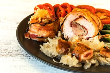 Roasted Pork Roll stuffed with sausage wrapped bacon and Cheese. Pork roll with vegetable. Cabbage.