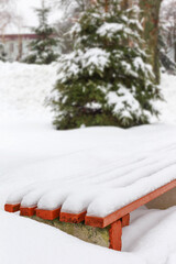 Bench in a park covered completely by snow after heavy snowfall