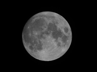 Extreme telephoto black and white shot of the full moon against a totally black sky