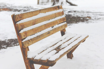 Bench in a park covered completely by snow after heavy snowfall