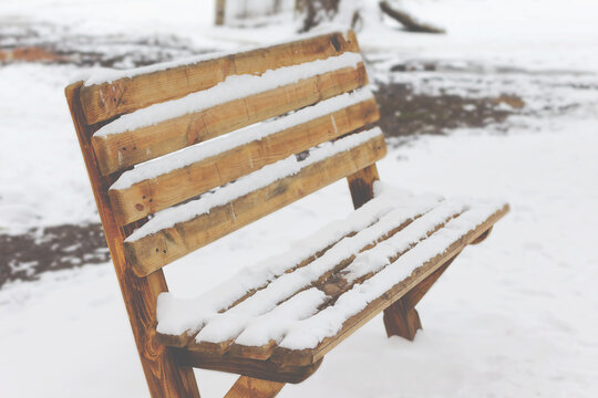 Bench in a park covered completely by snow after heavy snowfall © Elena
