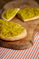 Homemade potato focaccia on a wooden cutting board.
