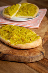 Homemade potato focaccia on a wooden cutting board.