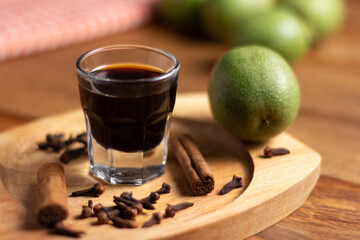 homemade nocino with green walnuts, cinnamon sticks and cloves.