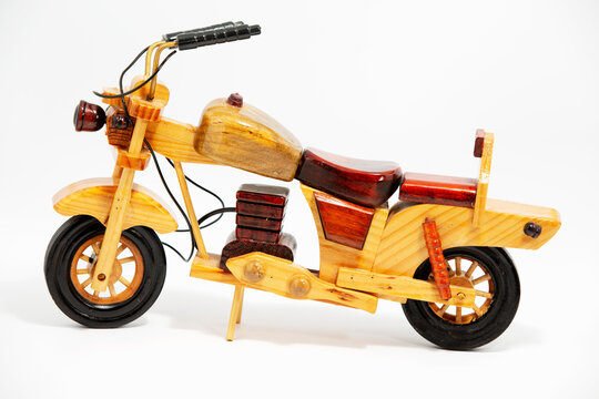 Miniature wooden motorcycle isolated on a wooden surface. Perfect gift for kids or motorbike lovers.