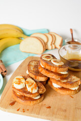 French toast with banana and homemade caramel with cinnamon, Breakfast dessert on a blue plate on a light background