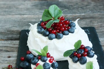 Anna Pavlova dessert with blueberries and red currants