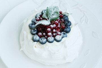 Anna Pavlova dessert with blueberries and red currants