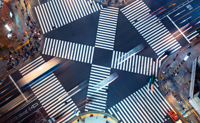 Traffic and people cross a busy intersection in Ginza, Tokyo