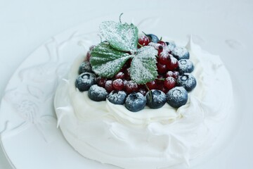 Anna Pavlova dessert with blueberries and red currants