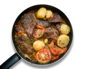 Homemade lunch. Pieces of meat in the iron pan. Isolated on white background.