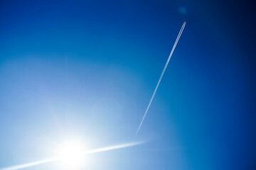 Airplane flying in the blue sky and sunlight