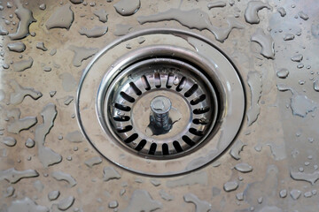 Obraz premium Kitchen sink plug hole closeup with water