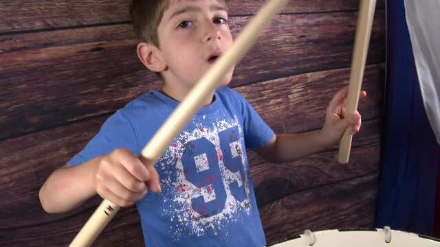 4k 50fps Child plays with drumsticks a military drum