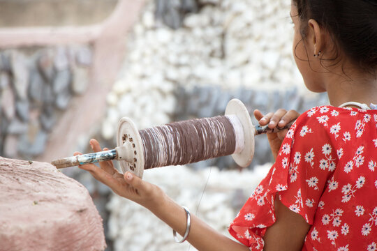 Girl with a kite thread rollerin her hand
