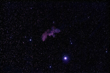 A whimsical nebula in outer space that resembles a witches head