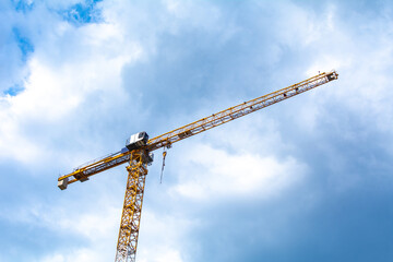 a tower crane in front of a cloudy sky