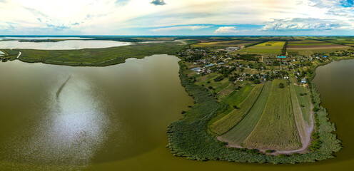 village houses of the village of Kinovia near the luman of the Beysug river (South of Russia, Krasnodar Territory) -  low aerial panorama with a sunny hot summer day
