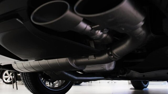 Bottom view of the exhaust system of the new luxury car at dealer showroom