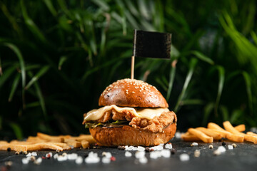 Close-up of home made tasty burger and french fries on stone table