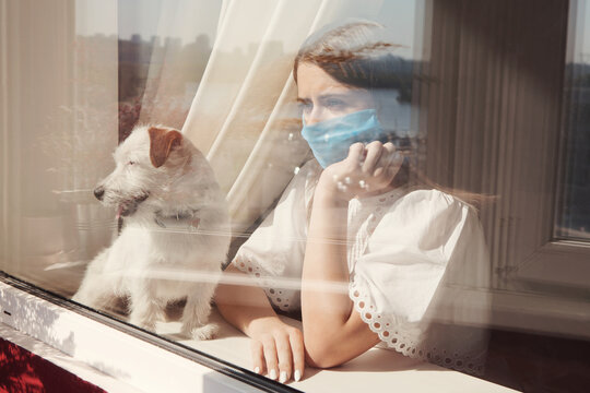 Young Woman In Medical Mask With Dog Jack Russell Broken Stay Isolation At Home For Self Quarantine. Concept Home Quarantine, Prevention COVID-19, Coronavirus Outbreak Situation