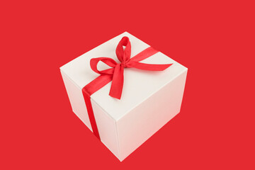 Holiday greetings concept. Close-up of gift to Red background.