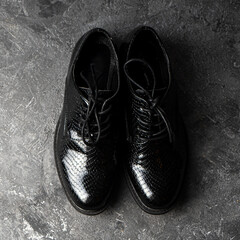 Elegant unisex black shoes standing on the concrete background. Top view.