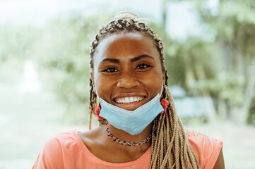 Portrait of young happy smiling African American girl wearing surgical mask, concept of health and...