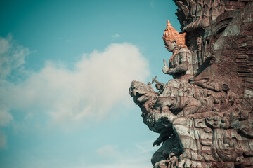 Landscape picture of tallest Garuda Wisnu Kencana GWK statue as Bali landmark with blue sky as a...